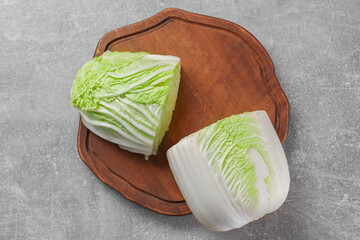 Halves of fresh Chinese cabbage on light grey table, top view
