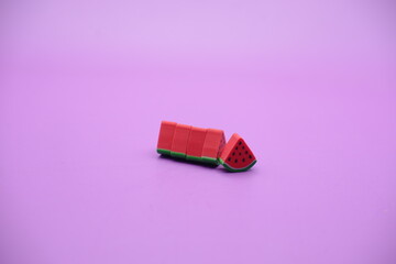 Mini watermelon toy isolated on purple background. purple background with watermelon toys.