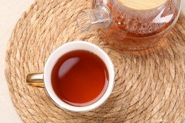 Aromatic tea in cup and teapot on table, top view