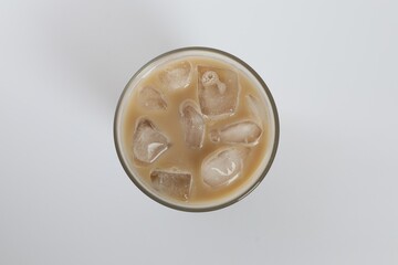 Iced coffee in glass on white background, top view