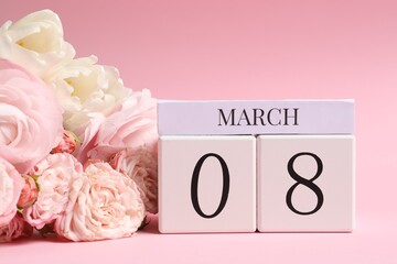 International Women's day - 8th of March. Wooden block calendar and beautiful flowers on pink...