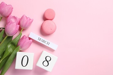 International Women's day - 8th of March. Macaron cookies, wooden block calendar and beautiful flowers on pink background, flat lay. Space for text - obrazy, fototapety, plakaty