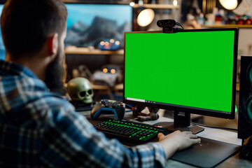 Man using computer with green screen in technology workspace