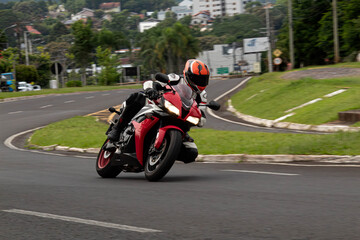 moto esportiva vermelha fazendo a curva