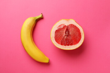 Banana and half of grapefruit on pink background, flat lay. Sex concept