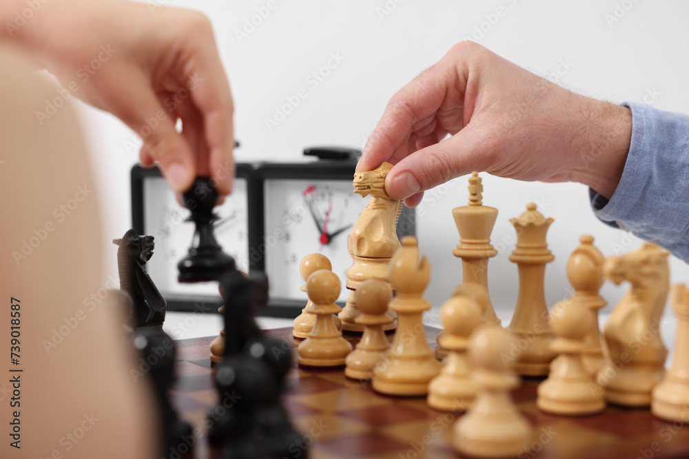 Wall mural Father and son playing chess at table indoors, closeup