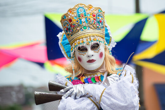 People wearing Venetian carnival-style masks are seen during the carnival in the city of Maragogipe, in Bahia.
