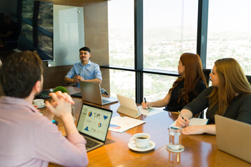 Businessman in a wheelchair giving a presentation to a group of people in a meeting room