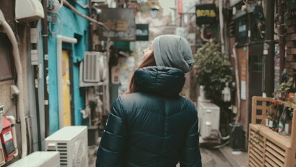 Tourist girl explore Japanese culture walking small old Tokyo street. Back view