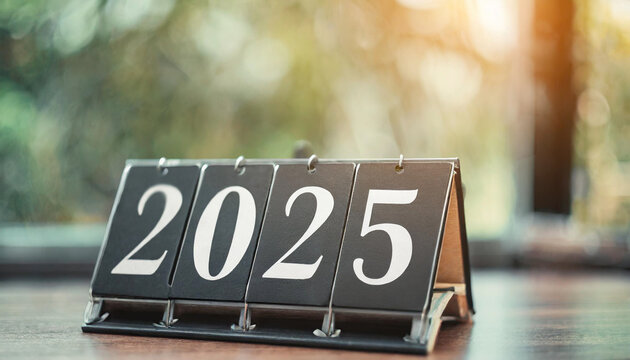 flip board displaying "2025" against a blurred background, symbolizing transition and anticipation