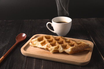 Waffles and coffee on rustic wood background