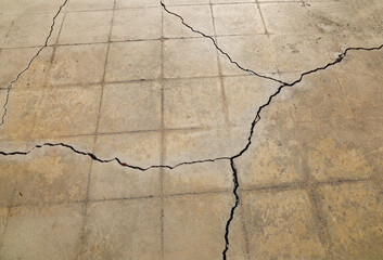 View of a patio's cracked cement due to ground settling below.