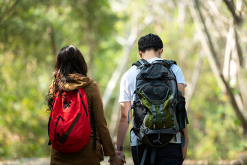 Tourist and traveler asian couple backpack enjoy and happy the jungle forest nature park . Traveler going camping and explore outdoors destination leisure