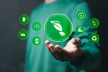 Reducing carbon footprint concept. Sustainable development and green business from renewable energy Reducing CO2 emissions, net zero target. Businessman holding human footprint icon on virtual screen.
