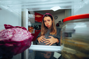 Pregnant Woman Looking in the Frige Feeling Hungry. Mother to be dealing with picky eating during...