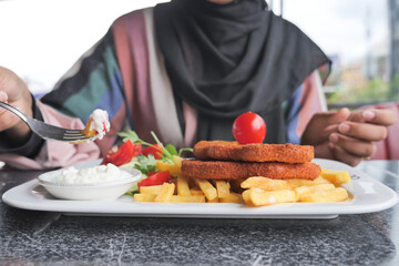 women eating Chicken schnitzel served with potato chips 