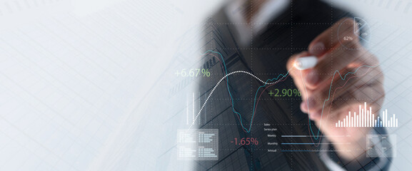 Businessman pointing financial graph growth and stock market chart, analyzing business data to...
