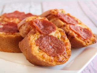 GARLIC BREAD TOPPED WITH CHEESE AND PEPPERONI served in dish isolated wooden table top view arabic food appetizer