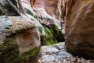 The extraordinary beauty of high mountains on both sides of shallow stream in gorge Wadi Al Ghuwayr or An Nakhil and wadi Al Dathneh near Amman in Jordan