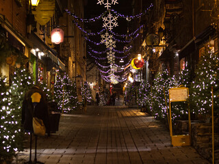 outdoor christmas decorations on a cobblestone street in old quebec city
