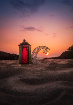 Eid Mubarak photography, Crescent moon with colourful lantern on the beach sand, Ramadan Kareem greeting background