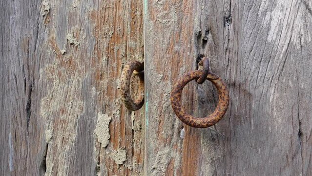 Rustic old wooden door and iron lock ring.
