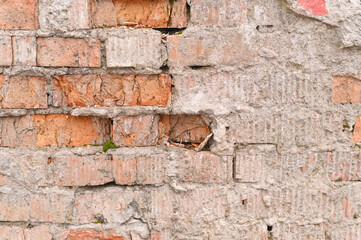 the plaster of the brick wall is crumbling