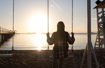 beautiful young woman on the swing on the sky background - obrazy, fototapety, plakaty