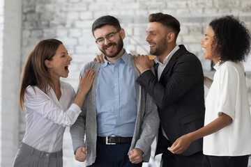 Congrats. Excited, smiling office workers congratulating their colleague after learning good news...