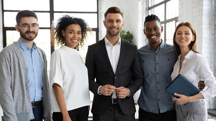 Happy colleagues at work. Aspiring young diverse coworkers smiling and looking at camera. Friendly...