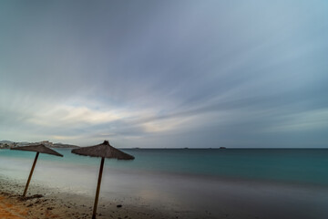 Stormy Day on a Lonely, Desolate White Sand Beach with Straw Umbrellas