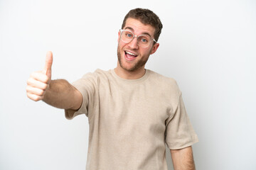 Young caucasian man isolated on white background with thumbs up because something good has happened