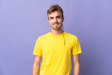 Young handsome blonde man isolated on purple background laughing