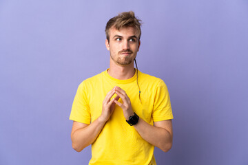 Young handsome blonde man isolated on purple background scheming something
