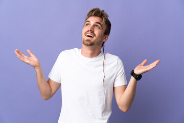 Young handsome blonde man isolated on purple background smiling a lot