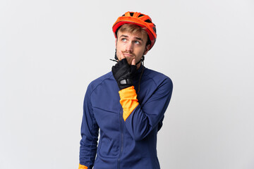 Young cyclist blonde man isolated on white background having doubts