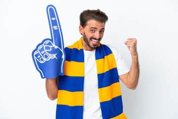 Young sports fan man isolated on white background celebrating a victory in winner position