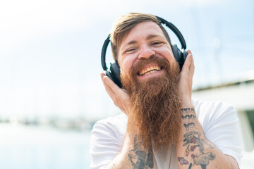Redhead man with beard listening music