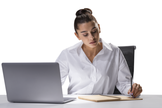 Focused businesswoman at desk writing in notebook with laptop, office work concept