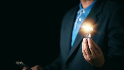 Idea innovation and inspiration concept. Hand of man holding illuminated light bulb, concept...