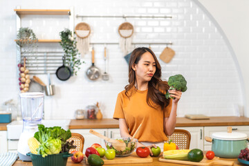 Portrait of beauty body slim healthy asian woman eating vegan food healthy with fresh vegetable salad in kitchen at home.diet, vegetarian, fruit, wellness, health, green food.Fitness and healthy food