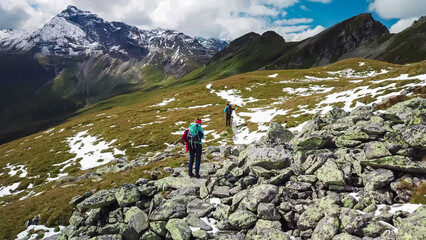 Aerial view of hiker couple on alpine meadow looking at majestic mount Vorderer Geisslkopf in High...