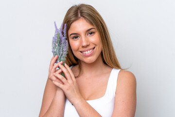 Naklejka premium Young caucasian woman isolated on white background holding a lavender plant. Close up portrait