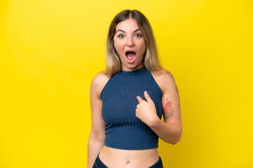 Young Rumanian woman isolated on yellow background with surprise facial expression