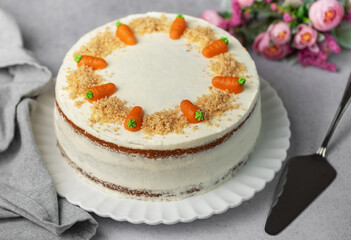 Homemade carrot cake made with walnuts, iced with cream cheese. Sweet dessert.