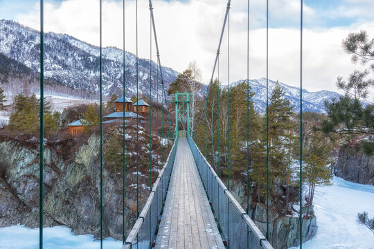 Suspension bridge to John Baptist skete Barnaul Znamensky women monastery in Patmos village of Chemal in winter. Altai Republic. Russia