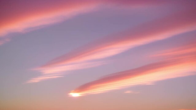 Mesmerizing pastel hues paint the sky in a captivating time lapse, as clouds dance gracefully across the horizon.
