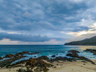 Rain clouds, rocks and sunrise at the seaside