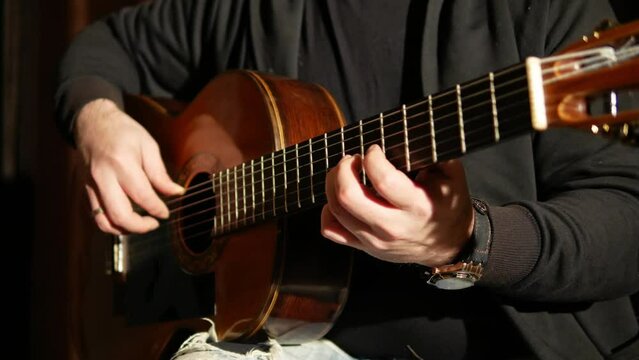 man playing acoustic guitar close-up