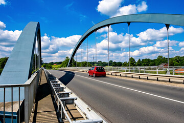 Red car drives over bridge